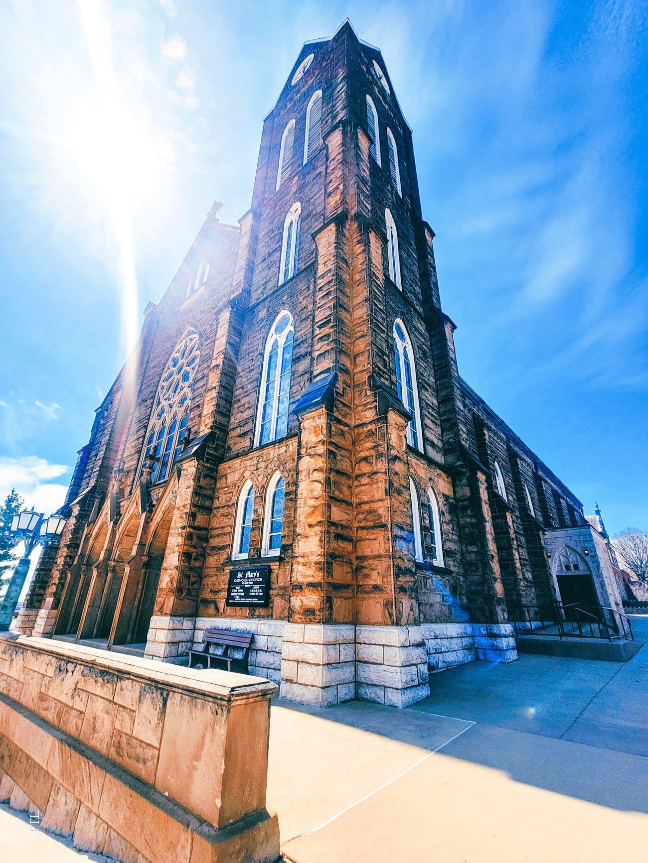 St. Mary's Catholic Church in Alton — limestone Gothic church with corner tower against a bright sky